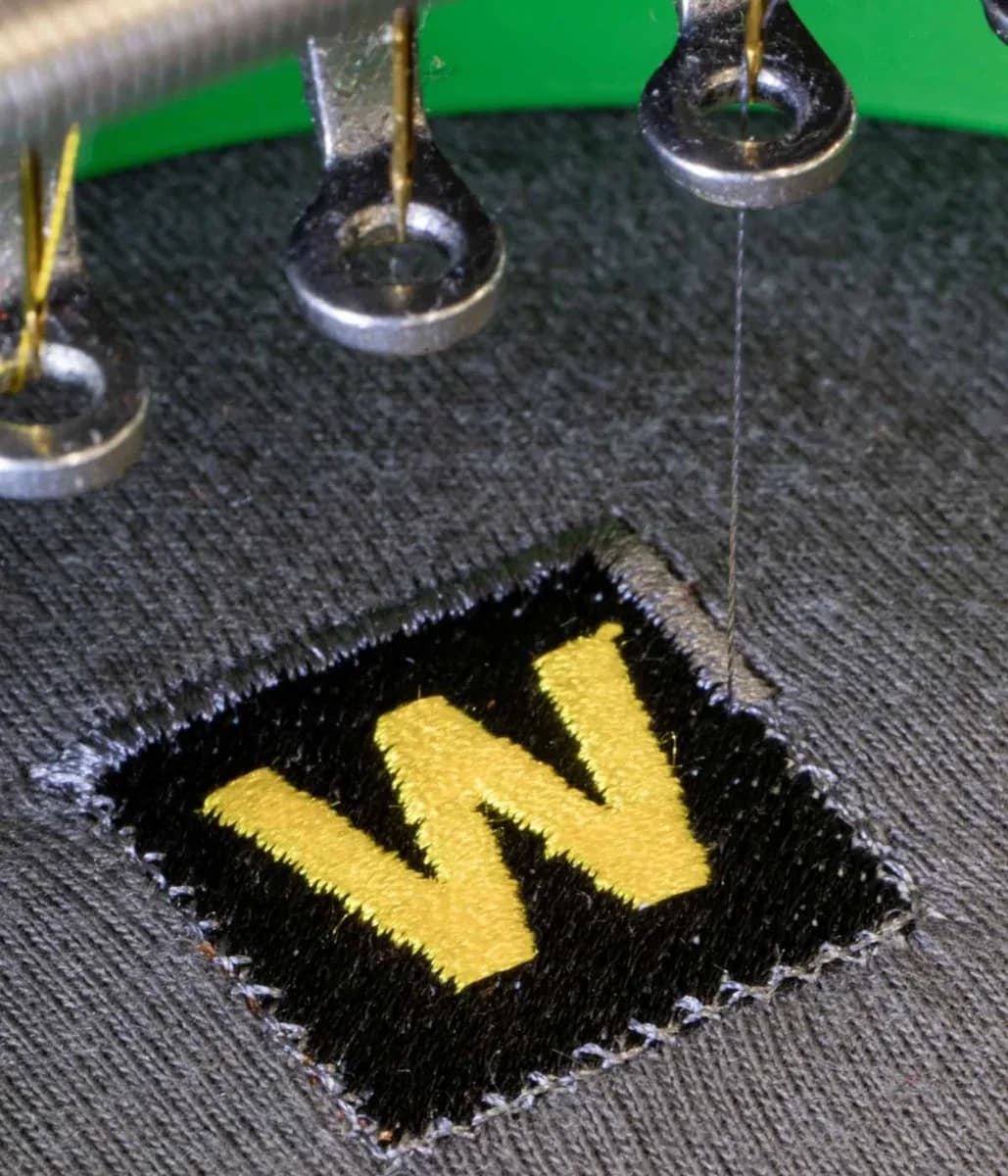 Industrial embroidery machine stitching company logo onto workwear — embroidery Orpington